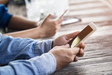 close up Man hand using or looking at his smartphone  for having lunch in the restaurant