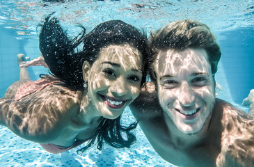 boy and girl having fun underwater.
