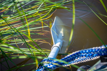 A paddle attached to a rubber boat rowing through the grass