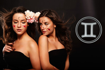 Two beautiful women with curly hair dressed in black dress looks like a Gemini sign