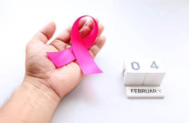 ribbons on hand and calendar February 4 concept World Cancer Day