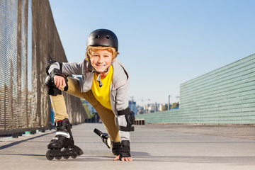 Smiling boy with inline skates and protective gear