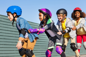 Happy children rollerblading together outdoors © Sergey Novikov