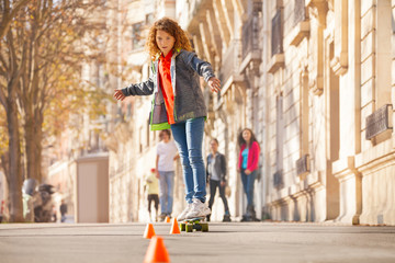 Skateboarder curving around the cones at side walk