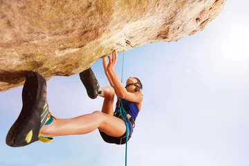 Gardinen Rock climber training outdoors against blue sky © Sergey Novikov