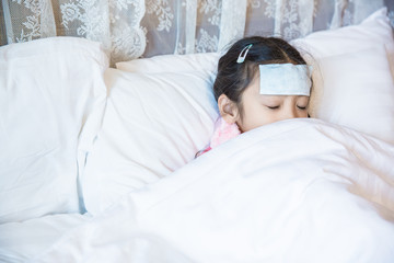 Little girl sick use fever patch and sleep on bed with white blanket