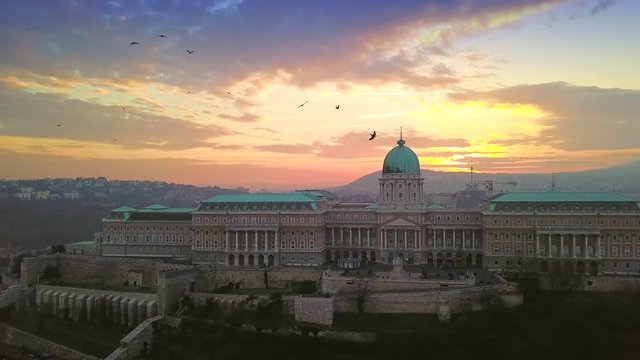 Budapest, Hungary - Aerial drone footage of Buda Castle Royal Palace with birds flying around at sunset