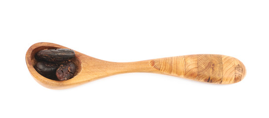 Wooden spoon of cocoa beans isolated