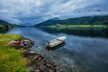 Fishing boat sailing on water with mountains in Norway.