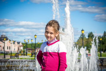 Naklejka premium Happy child posing at the fountain in the Park