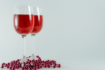 On a white background are two glasses with red wine