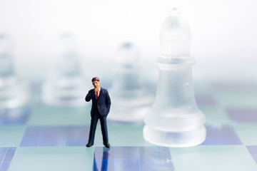 Miniature people, Businessmen standing on the chess game, find the solution for the business game,  use as a business competition concept.