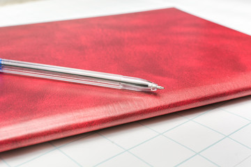 Classic blue pen lies on the beautiful red folder to study at the University