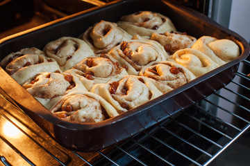 Rolls with cinnamon in the form of rolls are ready to be sent to the oven for a spoon