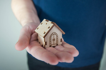 Man holding in hands little toy home