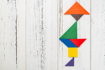 wooden tangram shaped like a people wearing a hat and standing on floor with copy space