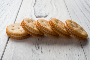sandwich biscuits with white cream filling on white wood background
