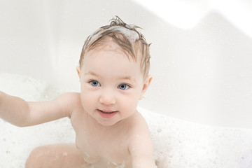 Happy baby girl bathing in bath