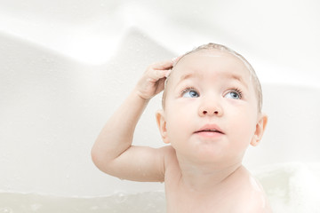 Happy baby girl bathing in bath