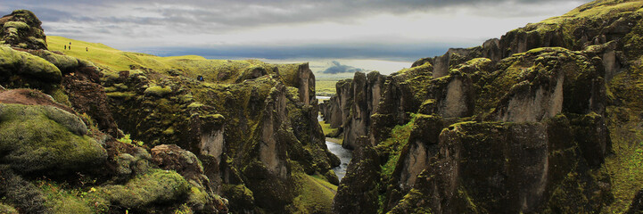 Blick auf einen gewundenen Fluss durch ein moosbedecktes Tal – Panorama der Schlucht der Eiszeit Fjadrárgljúfur in Island