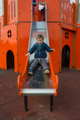 Fototapeta na wymiar The boy is playing on a slide