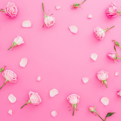 Floral frame with roses flowers and petals on pink background. Flat lay, Top view. Valentines day background