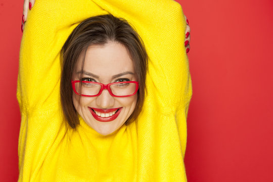 beautiful happy woman with red glasses on red background