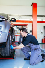 Auto mechanic repairing car.