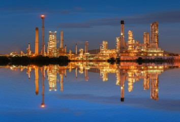 Obraz premium Oil refinery at twilight with reflection on water