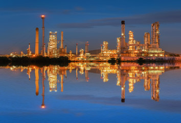 Oil refinery at twilight with reflection on water