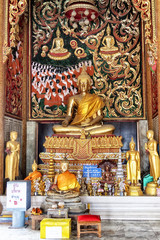 Golden buddha statue with diya lights.