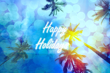 Fototapeta na wymiar Happy holidays text with coconut trees and color sky