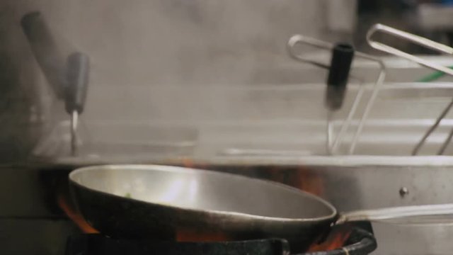 Chef is stirring vegetables in a pan