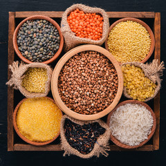A set of cereals and grains in a wooden basket on a wooden background. Top view. Copy space.