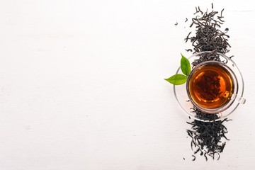 A cup of black tea on a wooden background. Top view. Copy space.