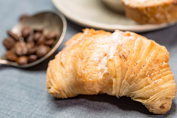 Sizilianisches Blätterteig Gebäck mit Kaffebohnen in einem silbernen Löffel