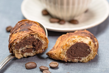 Sizilianisches Blätterteig Gebäck mit Schokoladenfüllung und Kaffetasse mit  Kaffebohnen