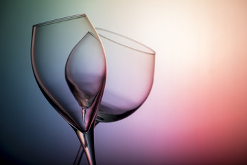Close up view of two aligned empty glasses of wine isolated on neon background