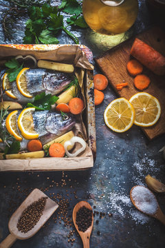 Salmon on rustic table with fresh ingredients for cooking