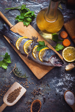 Salmon on rustic table with fresh ingredients for cooking