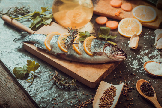 Salmon on rustic table with fresh ingredients for cooking