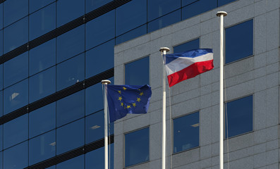 drapeau européen et français sur immeuble moderne de verre à Paris