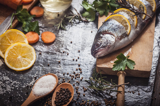 Salmon on rustic table with fresh ingredients for cooking