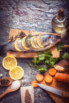 Salmon on rustic table with fresh ingredients for cooking