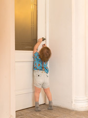 The child opens the door from the room