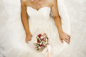 beautiful bouquet of different colors in the hand of the bride in a white dress