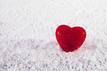 Fototapeta premium the Red glass heart on white artificial snow