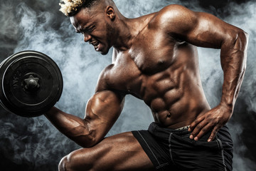 Muscular young fitness sports man workout with dumbbell in fitness gym