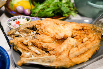 Thai fried fish on plate with vegetables
