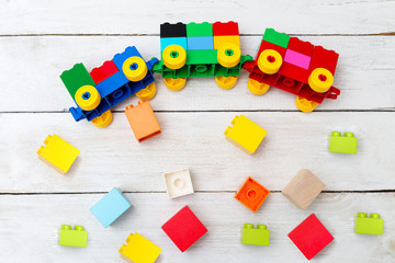 A toy train of cubes of blocks on a wooden background. Early learning.